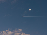 Avión pasando cerca de la luna de día.